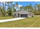 Charming single-story home with gray accents, a gray garage door, and landscaping at 9695 Sw 125 Court Rd, Dunnellon, FL 34432