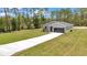 Exterior view of a modern home with a well-manicured lawn and long driveway at 9695 Sw 125 Court Rd, Dunnellon, FL 34432