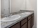Bathroom featuring double sinks with stylish marble countertops and dark wood cabinetry at 979 Sun Burst Rd, Winter Haven, FL 33880