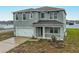Two-story home featuring a gray exterior, a two-car garage, and a covered front porch at 979 Sun Burst Rd, Winter Haven, FL 33880