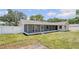 Spacious backyard featuring green grass, a screened porch, and white perimeter fence at 99 Eastridge Dr, Eustis, FL 32726