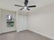 Bedroom featuring a ceiling fan, a window view of trees, and closet space at 99 Eastridge Dr, Eustis, FL 32726
