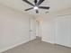 Bright bedroom with a ceiling fan, tiled floors, closet space, and white walls at 99 Eastridge Dr, Eustis, FL 32726