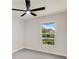 Bedroom with a ceiling fan, a window view of foliage, neutral walls, and tile floors at 99 Eastridge Dr, Eustis, FL 32726