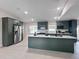 Large kitchen showcasing dark green cabinets, stainless steel appliances, and a central island with white countertop at 99 Eastridge Dr, Eustis, FL 32726