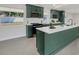 Modern kitchen featuring dark green cabinetry, a center island, stainless appliances, and lots of natural light at 99 Eastridge Dr, Eustis, FL 32726