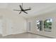 Bright living room features a ceiling fan, a large window and a glass panel door at 99 Eastridge Dr, Eustis, FL 32726