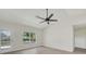 Bright living room features a ceiling fan, a large window and a glass panel door at 99 Eastridge Dr, Eustis, FL 32726