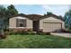 Charming single-Gathering home featuring a two-car garage, stone accents, and lush landscaping at 1110 Cumberland Trail Dr, Lake Hamilton, FL 33851