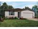 Inviting single-Gathering home featuring neutral paint, a well-kept lawn, and charming stone accents at 1122 Cumberland Trail Dr, Lake Hamilton, FL 33851