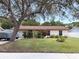 Charming single-story home featuring a well-maintained front yard with mature tree and colorful play set at 1150 Jackson St, Oviedo, FL 32765