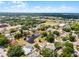 Community aerial view featuring a pond, manicured lawns, and mature trees under a partly cloudy sky at 117 Clowson Ct, Ocoee, FL 34761