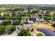 Aerial view of homes in a quiet neighborhood near a tranquil pond surrounded by mature trees at 117 Clowson Ct, Ocoee, FL 34761
