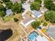 Beautiful aerial view of a home with pool, a pond, and mature trees in a suburban neighborhood at 117 Clowson Ct, Ocoee, FL 34761