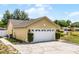 Two-car garage with white doors and a concrete driveway at 117 Clowson Ct, Ocoee, FL 34761