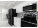 Bright kitchen featuring stainless steel appliances, black stove and refrigerator, white marble floors at 117 Clowson Ct, Ocoee, FL 34761