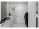 Well-lit laundry room with washer, dryer, and storage shelves at 117 Clowson Ct, Ocoee, FL 34761