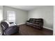 Living room featuring wood floors and a leather sofa and chair at 117 Clowson Ct, Ocoee, FL 34761