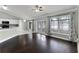 Bright living room features hardwood floors, vaulted ceilings, and adjacent white kitchen at 117 Clowson Ct, Ocoee, FL 34761