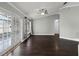 Spacious living room with hardwood floors, ceiling fan, and French doors leading to a sunroom at 117 Clowson Ct, Ocoee, FL 34761
