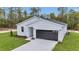 A modern home with gray garage door, board and batten siding, and fresh landscaping at 12197 Sw 76 Ln, Dunnellon, FL 34432