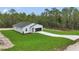 A cozy home features lush greenery, freshly laid sod, and a smooth concrete driveway at 12197 Sw 76 Ln, Dunnellon, FL 34432