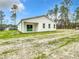 The back exterior of the home features a large yard, windows and patio at 12197 Sw 76 Ln, Dunnellon, FL 34432