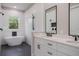 Bright bathroom features a modern tub under a window and double vanity with black hardware at 12460 Sw 48 Lane Rd, Ocala, FL 34481