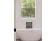 Modern bathroom features a stand-alone soaking tub and a view of the outdoors at 12460 Sw 48 Lane Rd, Ocala, FL 34481