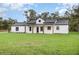 Charming white farmhouse with a metal roof and a large front yard at 12460 Sw 48 Lane Rd, Ocala, FL 34481