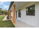 Inviting front porch featuring stylish wood posts and modern black windows at 12460 Sw 48 Lane Rd, Ocala, FL 34481
