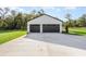Two-car garage with modern doors and a concrete driveway, surrounded by a green lawn at 12460 Sw 48 Lane Rd, Ocala, FL 34481