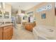 Luxurious bathroom featuring a soaking tub, granite countertop and double vanities, and a glass door shower at 13524 Glynshel Dr, Winter Garden, FL 34787