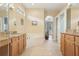 Bright bathroom boasting a soaking tub, custom cabinetry, and tile floors with a view to the main bedroom at 13524 Glynshel Dr, Winter Garden, FL 34787