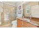 Well-lit bathroom featuring a granite countertop, tiled shower with glass doors, and neutral-toned walls at 13524 Glynshel Dr, Winter Garden, FL 34787