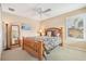 Comfortable bedroom with wooden bed frame, soft lighting and window with plantation shutters at 13524 Glynshel Dr, Winter Garden, FL 34787