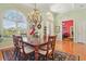 Elegant dining room with a wood table, ornate chandelier, and views into the living and office areas at 13524 Glynshel Dr, Winter Garden, FL 34787