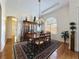 Well-lit formal dining room with chandelier, hardwood floors, and large arched window at 13524 Glynshel Dr, Winter Garden, FL 34787