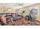 Versatile living room featuring a comfy leather couch, exercise machines, hardwood floors, and neutral paint at 13524 Glynshel Dr, Winter Garden, FL 34787