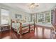 Spacious main bedroom with dark wood floors and built-in shelves with a seating area by the windows at 13524 Glynshel Dr, Winter Garden, FL 34787