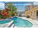 Beautiful screened-in pool area with lush tropical plants, spa, and outdoor seating at 13524 Glynshel Dr, Winter Garden, FL 34787