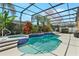 Relaxing screened-in pool area with lush tropical plants and a soothing spa at 13524 Glynshel Dr, Winter Garden, FL 34787