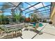 Secluded screened-in pool with lounge seating, dining and verdant tropical landscaping at 13524 Glynshel Dr, Winter Garden, FL 34787