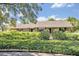 Inviting single-story home with lush landscaping in front of the house and well-maintained bushes at 1387 Sawgrass Court, Winter Park, FL 32792