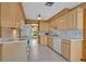 Bright kitchen features wooden cabinets, white appliances, and a garden view through the window at 1387 Sawgrass Court, Winter Park, FL 32792