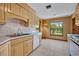 Bright kitchen featuring wood cabinets, white appliances, and a picturesque window view at 1387 Sawgrass Court, Winter Park, FL 32792