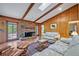 Comfortable living room featuring a brick fireplace, wood-paneled walls, and cozy seating at 1387 Sawgrass Court, Winter Park, FL 32792