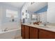 Bathroom with double sinks, a large mirror, and a separate bathtub and shower area at 14617 Keelford Way, Orlando, FL 32824