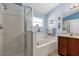 Well-lit bathroom featuring a glass-enclosed shower, a separate bathtub, and modern fixtures at 14617 Keelford Way, Orlando, FL 32824