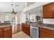 Kitchen featuring stainless steel dishwasher, granite counters, and hardwood floors viewed from living room at 14617 Keelford Way, Orlando, FL 32824